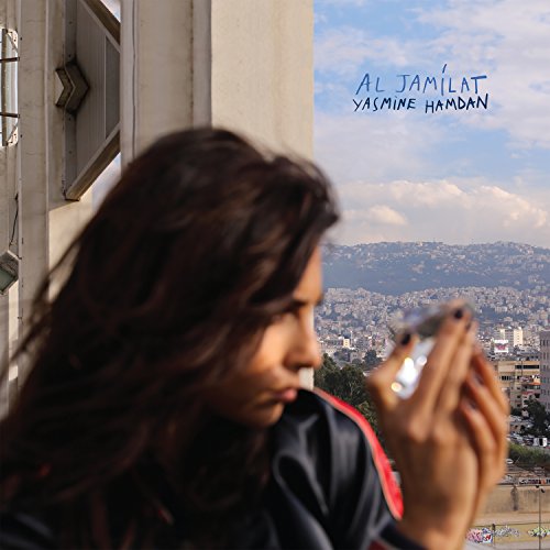 "Vinyl album cover featuring a woman holding a camera, overlooking a cityscape."