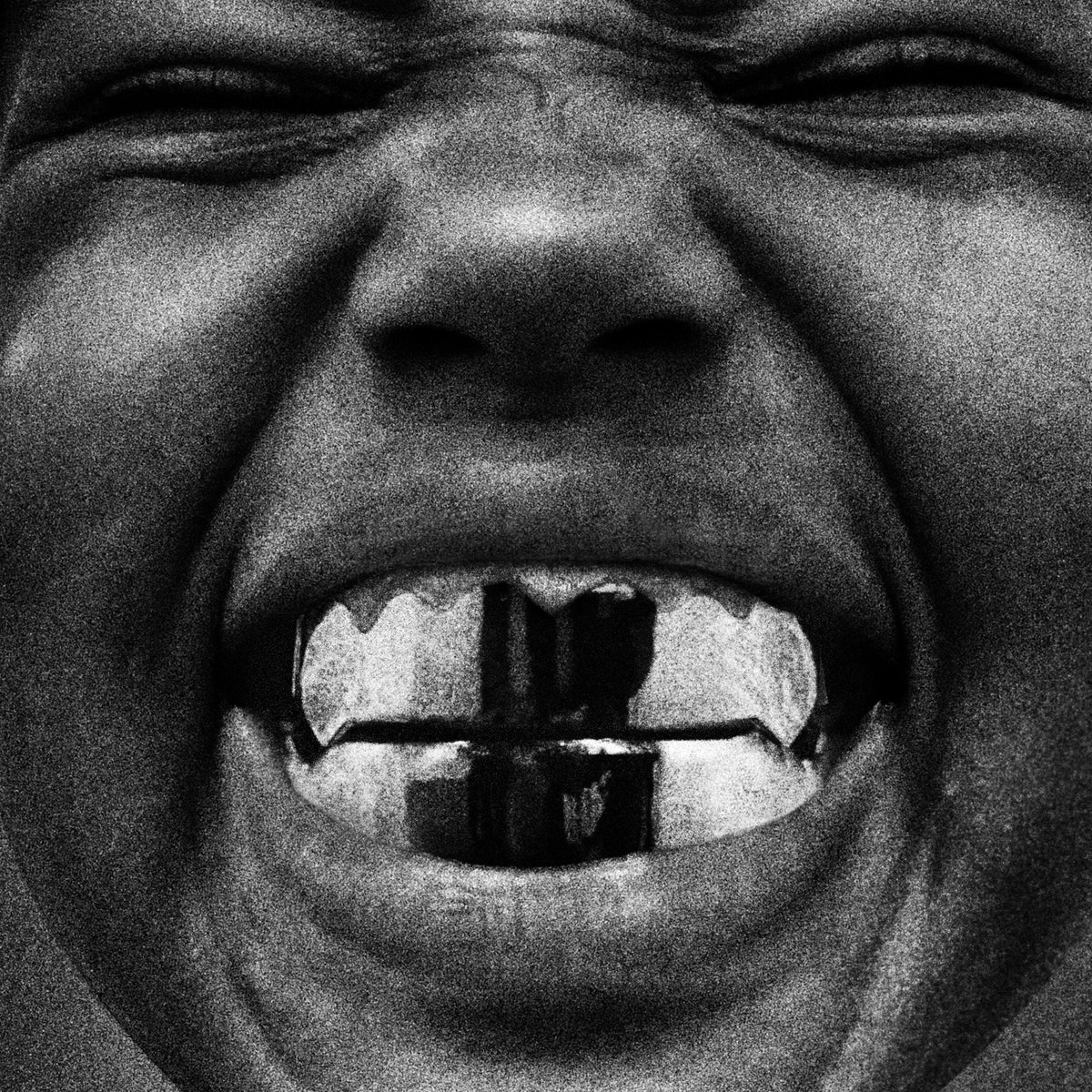 Black and white close-up of a person with grillz in their mouth.