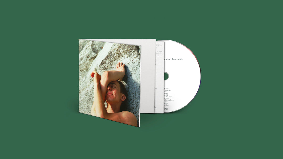 CD case with a photo of a person lying in grass, looking up.