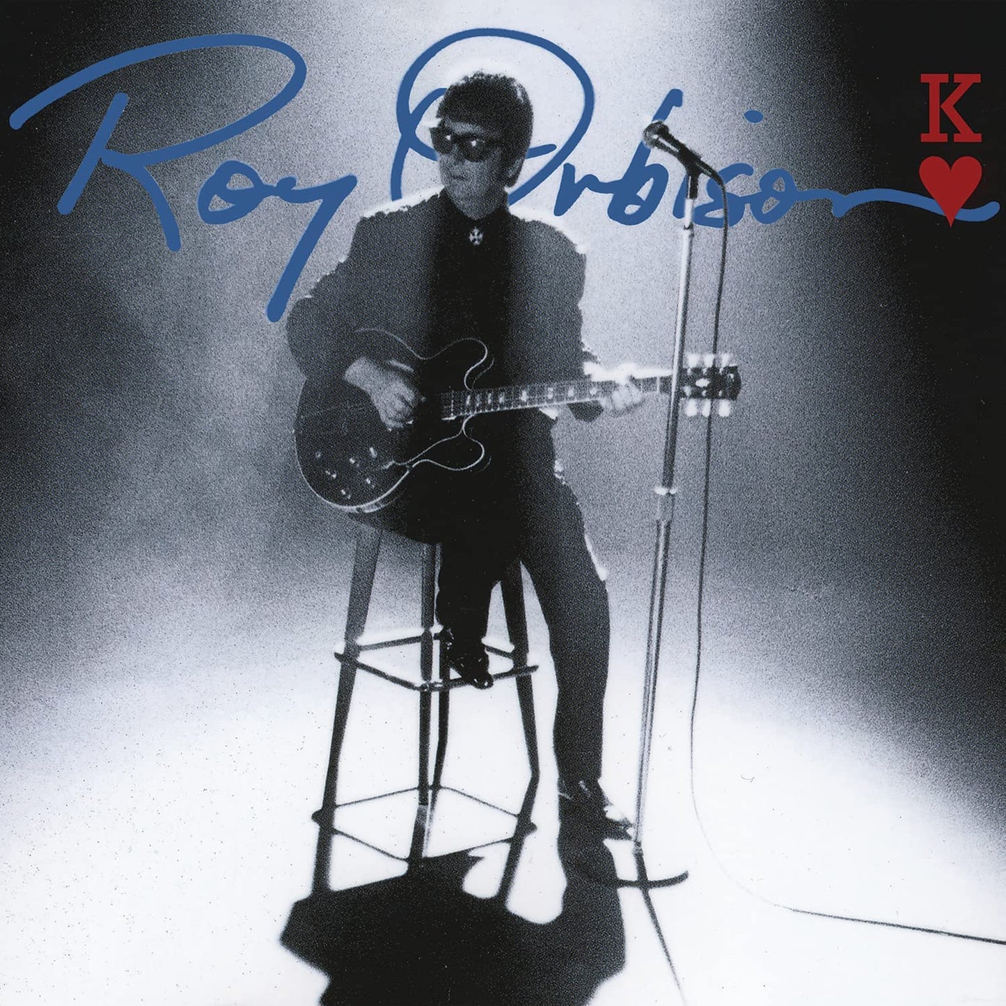 "Black and white album cover featuring Roy Orbison playing guitar on a stool."