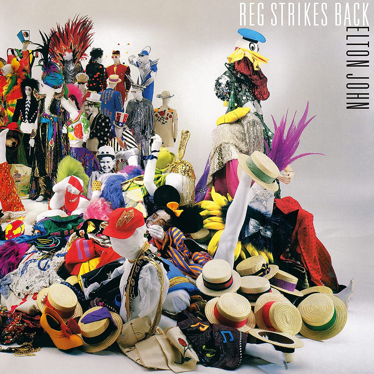 Elton John’s “Reg Strikes Back” vinyl album cover with many costumed figures.