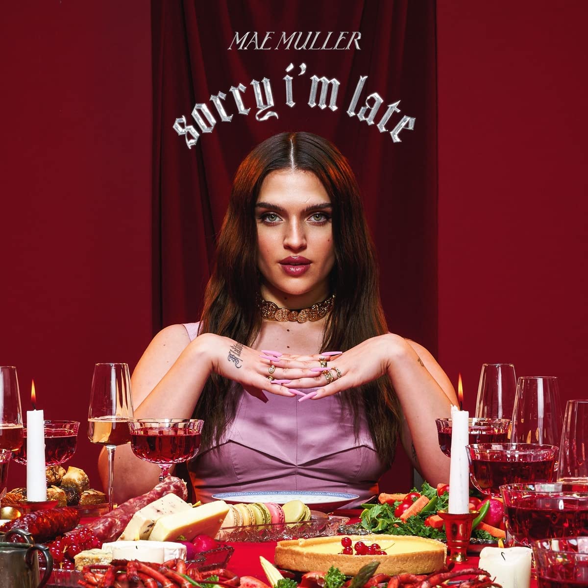 "Album cover with a woman surrounded by food and wine, titled 'Sorry I'm Late'."