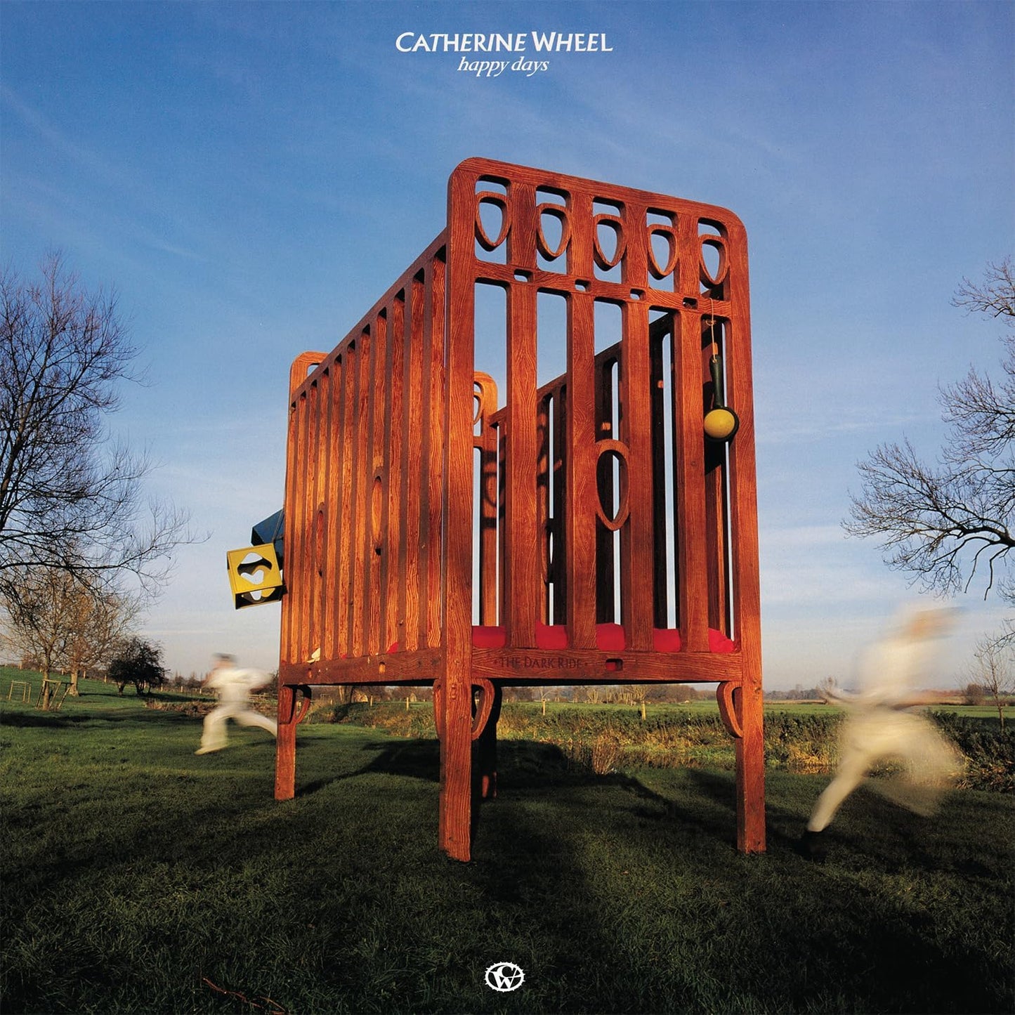 Album cover: wooden crib in a field under a blue sky.