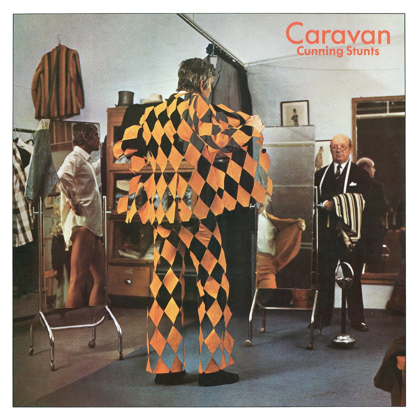 Album cover: man in diamond suit looking at reflection in mirror.