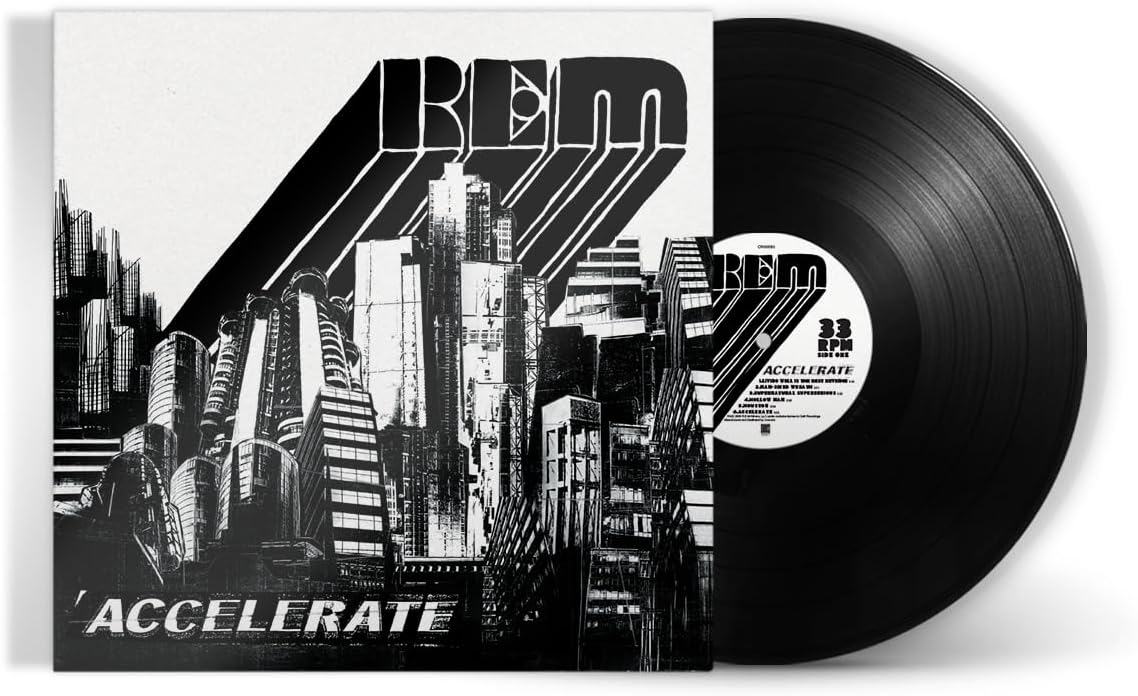 "Black vinyl record with white label, sleeve features cityscape and 'R.E.M. Accelerate' text."