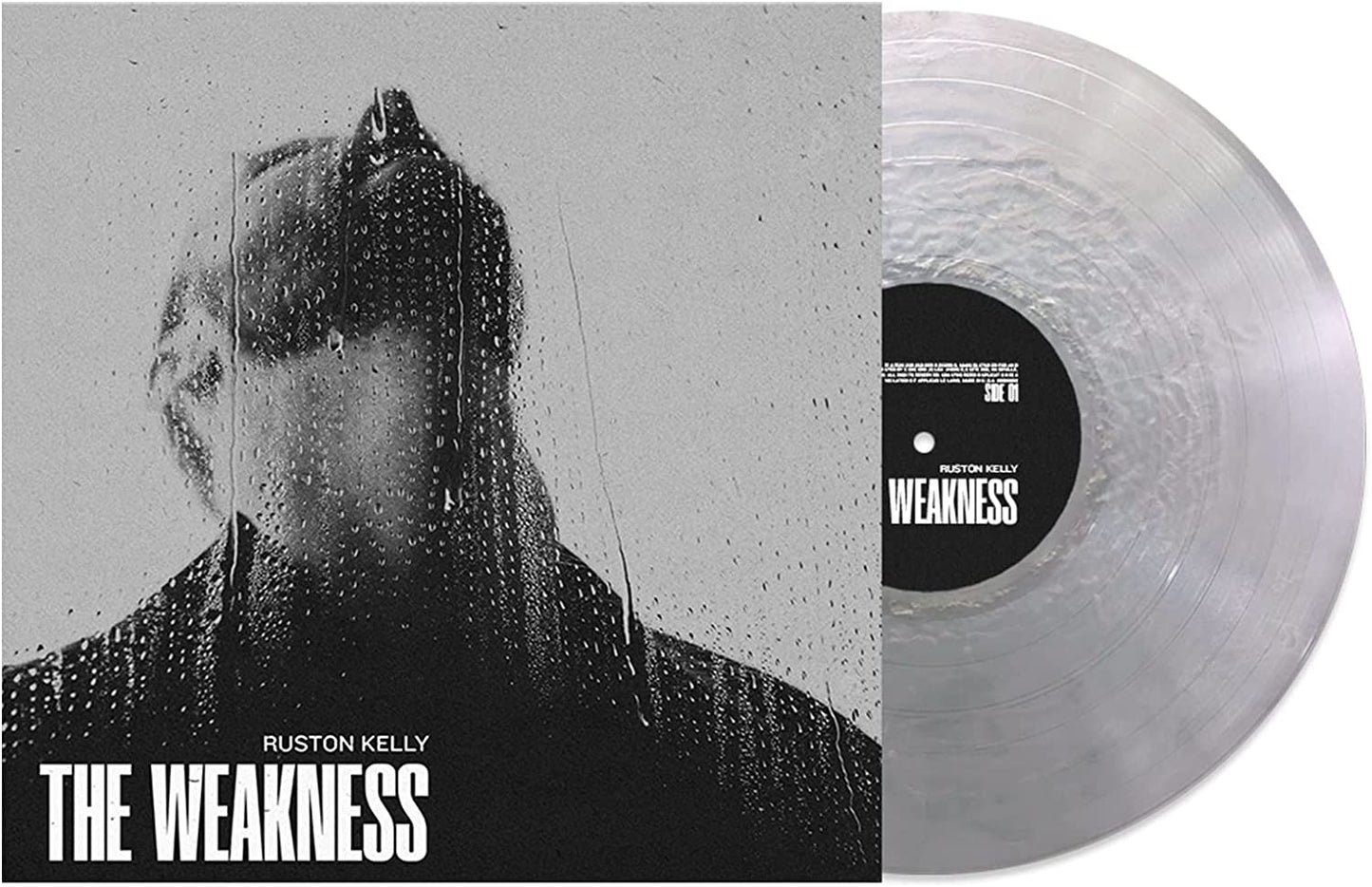 A vinyl record with a clear disc and a black label, alongside its album cover.
