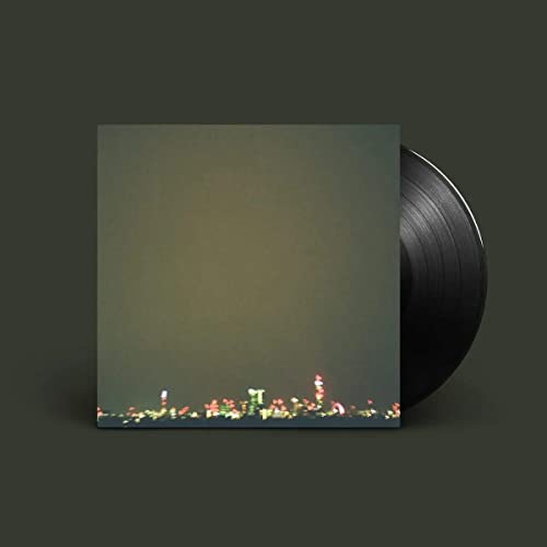Vinyl record with green cover featuring a blurred cityscape at the bottom.