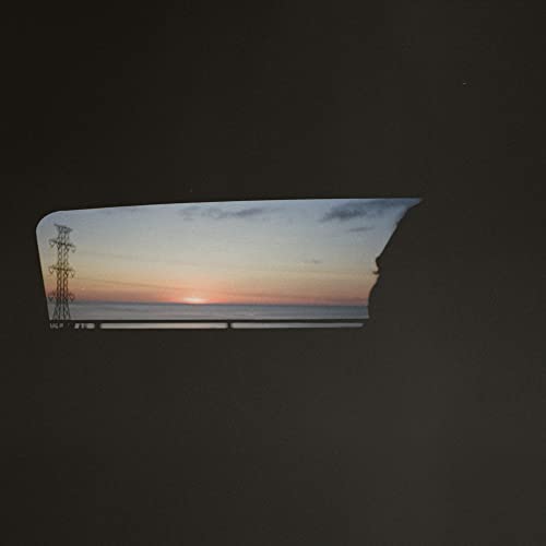 Record cover with a sunset viewed through a car’s rear window.
