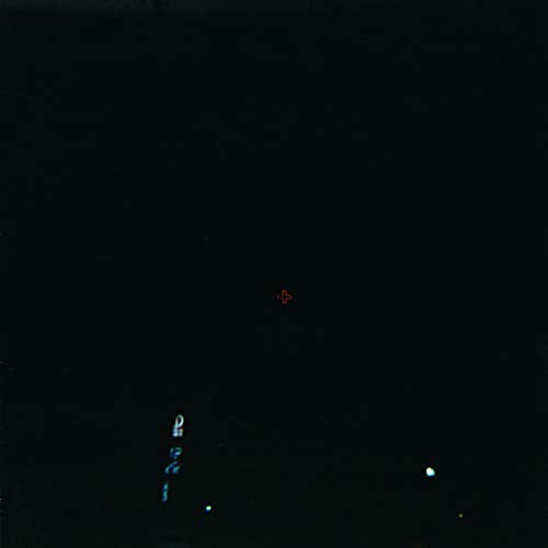 Dark album cover with a small red cross and blurred city lights.