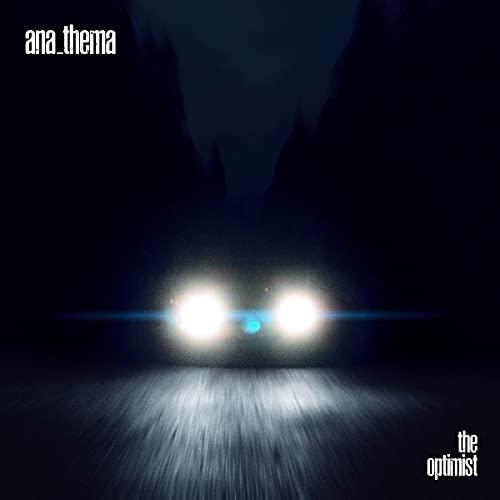 Dark album cover with car headlights shining down a blurred road.