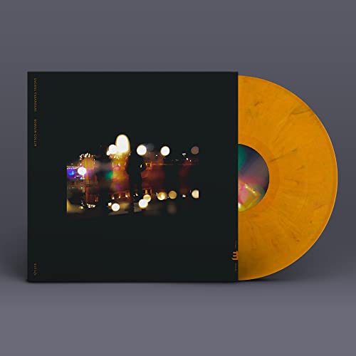 Vinyl record and album cover with a blurred nighttime city scene.