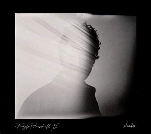 "Album cover with blurred black and white image of a man's head and shoulders."