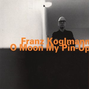 CD album cover featuring a man in dark attire against a stark, lit background.