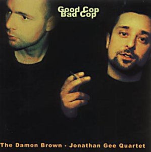 CD album cover featuring two men in black shirts against a dark background.