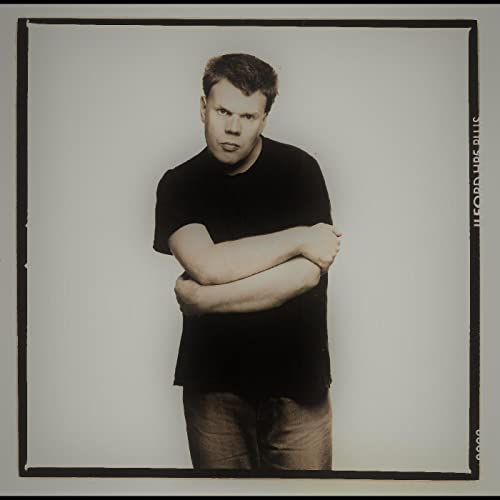 Black and white portrait of a man with crossed arms.