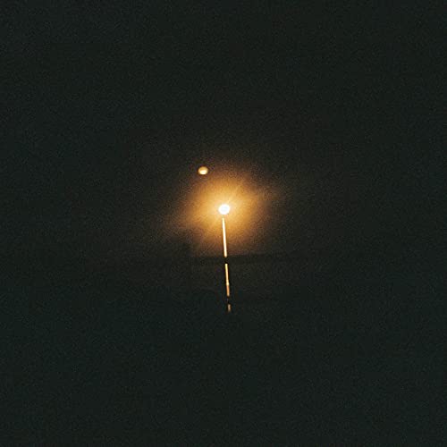 Dark album cover with a blurred, glowing light source.