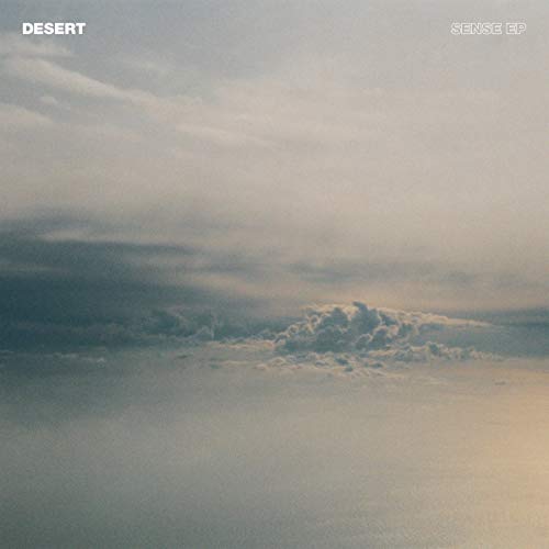 Vinyl record cover: hazy desert landscape with cloudy sky.