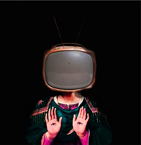 Person with hands raised before a vintage television screen.