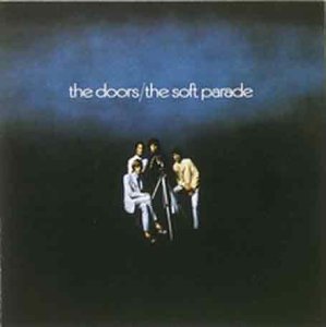 The image shows the album cover for "The Doors - The Soft Parade" vinyl. The alt text is: "The Doors album cover with three men standing against a dark blue background."