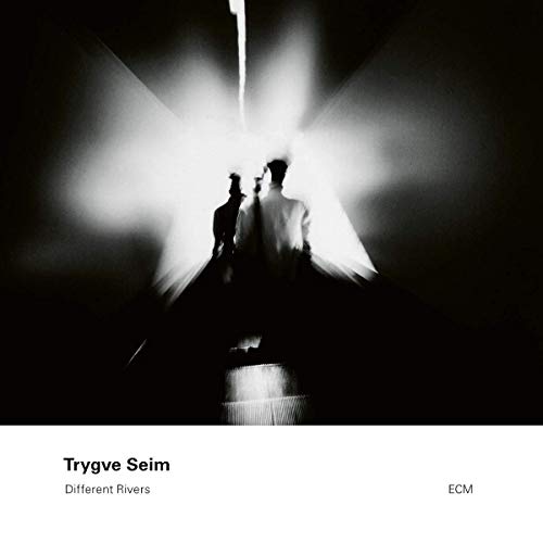 "Album cover featuring two silhouetted figures walking towards a bright light, black and white."