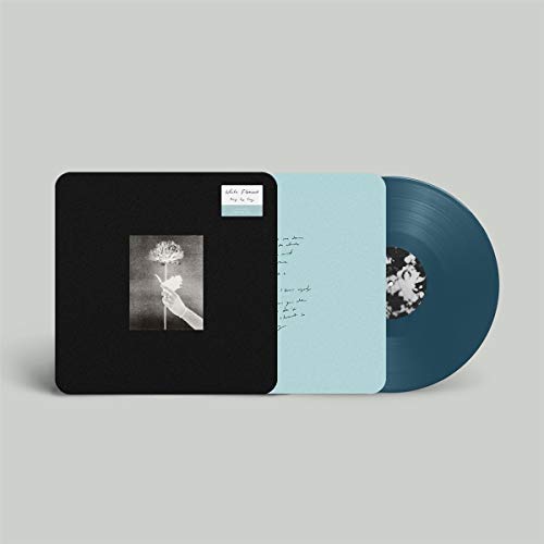 Vinyl record with black sleeve featuring a hand holding a white flower.