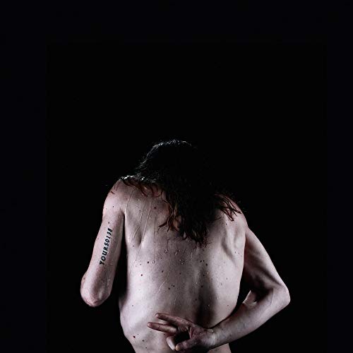 Back view of a person with long hair, wet skin, and back tattoo.