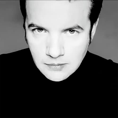 Black and white portrait of Pete Wylie, facing forward, wearing black.