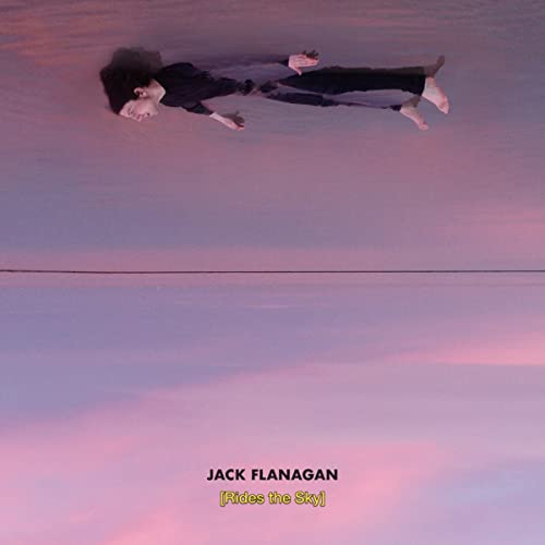 "Album cover featuring a man lying on a sandy beach at sunset."