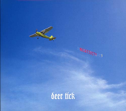 CD cover: airplane towing a banner reading "NEGATIVITY" in a blue sky.