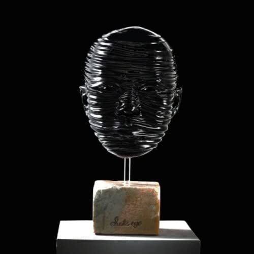 Sculptural head made of dark, wrapped material on a textured base.