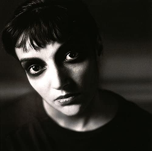 Black and white close-up portrait of a woman with dark hair and intense gaze.