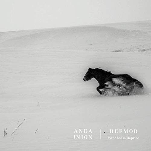 Black and white image of a horse running through a snowy landscape.