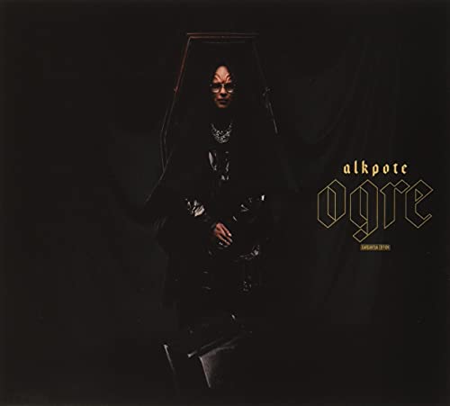 Dark album cover featuring a person in a coffin with ornate lettering.