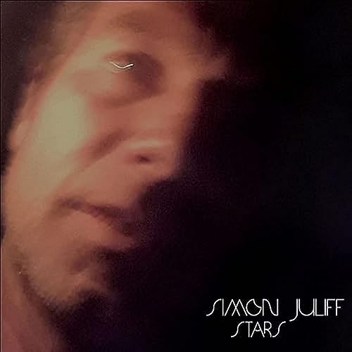Close-up of a man’s face with a paper airplane and album title.