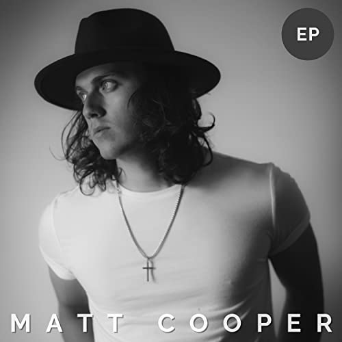 Black and white portrait of Matt Cooper wearing a hat and necklace.