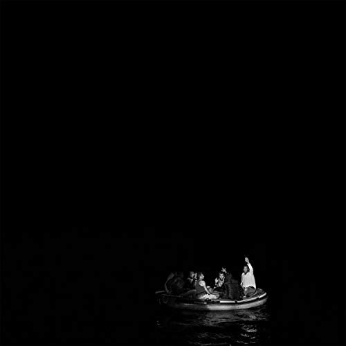 Black and white image of people in a small boat on water.