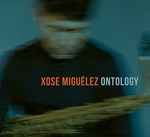 "Blurry image of a man playing a percussion instrument, with text overlay."