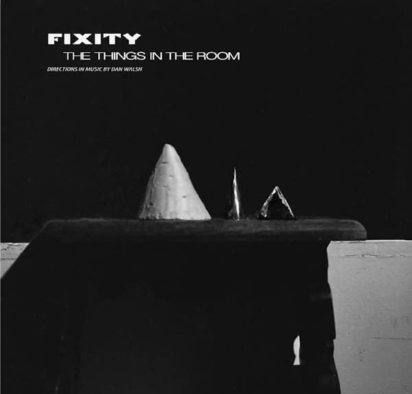 Black and white album cover with geometric shapes on a dark surface.