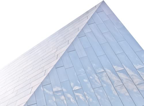 Glass pyramid structure against a bright, cloudy sky.
