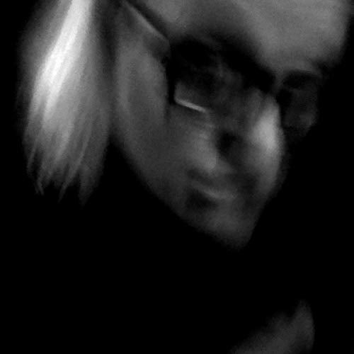 Blurred, grayscale portrait of a person with light hair and dark glasses.