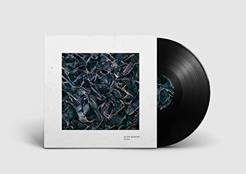 Vinyl record with album cover featuring fractured dark blue and black shapes.