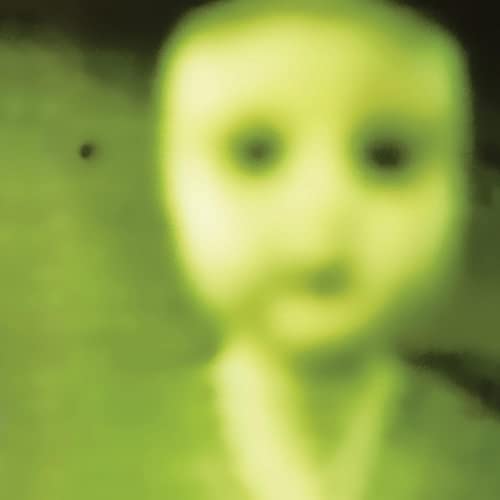 Blurred, greenish portrait of a person looking directly at the viewer.