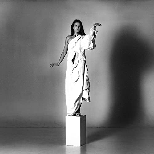 Black and white album cover featuring a woman in a white dress on a pedestal.