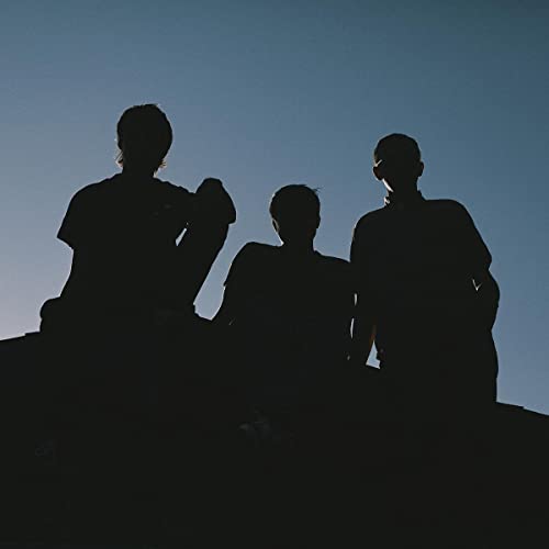 Silhouettes of three people against a pale blue sky.