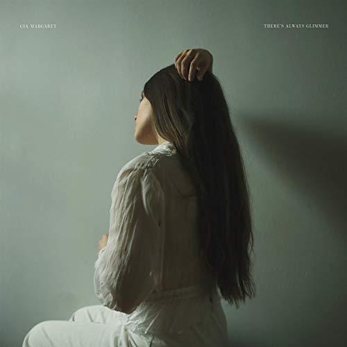 Woman with long dark hair in a white dress, album cover.