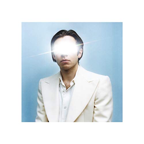 The image depicts a man in a white suit jacket and shirt, with a bright light obscuring his face. Alt text: Man in white suit with bright light over his face.
