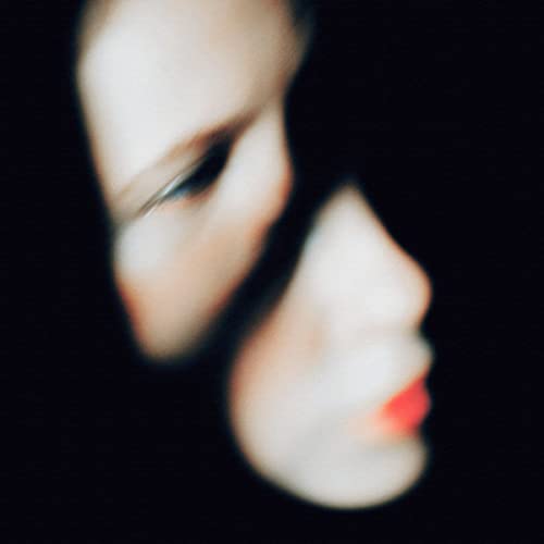 Blurred, soft-focus portrait of a woman in profile against black.