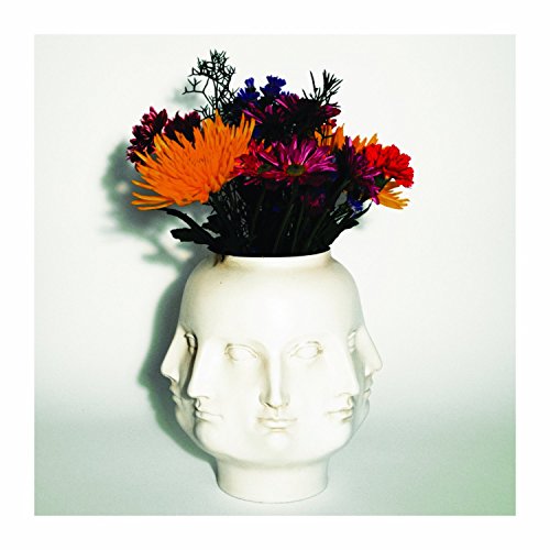 White vase in the shape of a face holding colorful flowers.