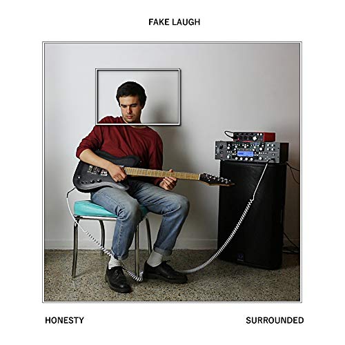 Man playing guitar with head replaced by empty picture frame.