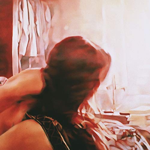 Blurred image of a person’s head and shoulders in a room.